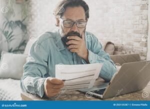 persona confundida frente a computadora y facturas